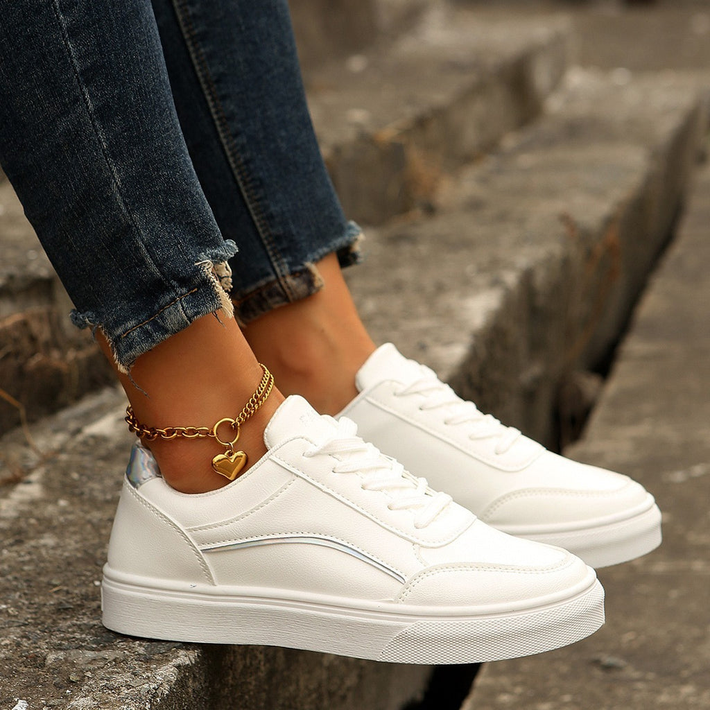 Women’s white round-toe flats with thick sole, casual lace-up style.