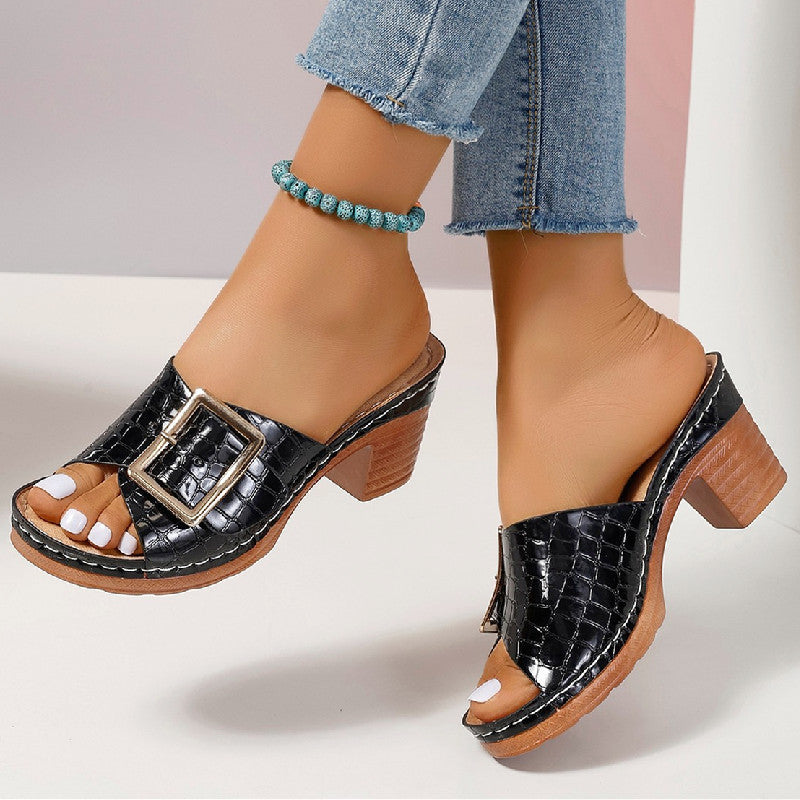Women’s crocodile-textured buckle slides with chunky heel and peep toe.
