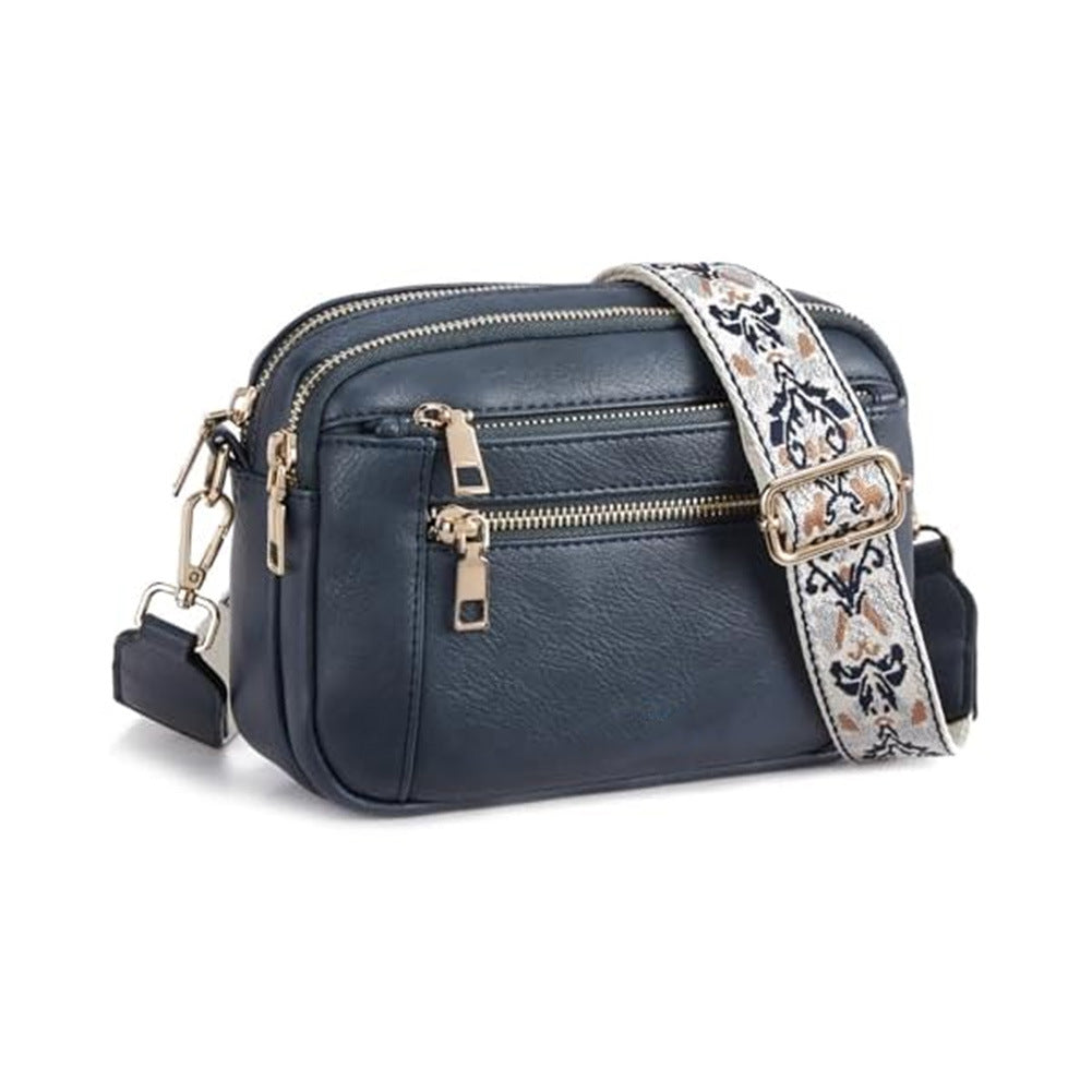 Women’s triple-zip colorblock crossbody bag with embroidered strap.