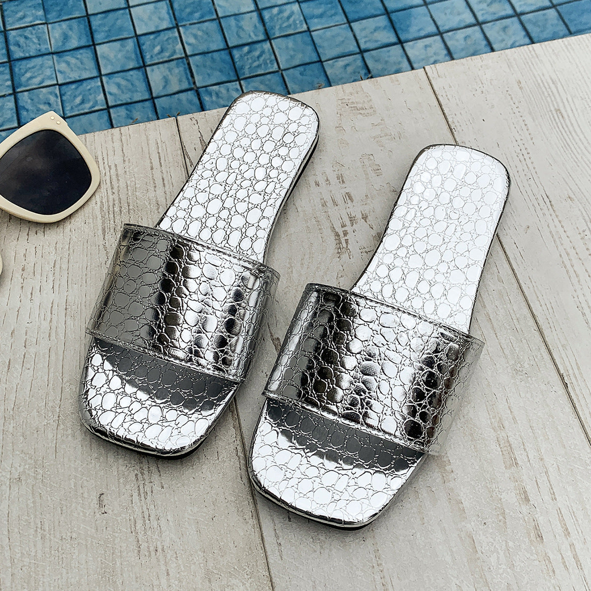 Women’s crocodile-textured square-toe flat slides, perfect for summer beach wear.