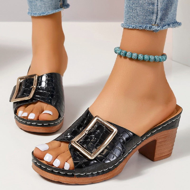 Women’s crocodile-textured buckle slides with chunky heel and peep toe.