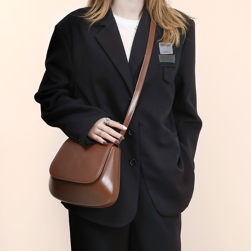 Women’s vegan leather retro saddle crossbody bag with adjustable strap.