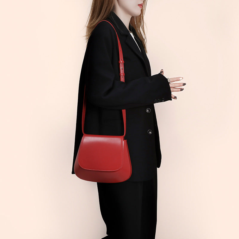 Women’s vegan leather retro saddle crossbody bag with adjustable strap.
