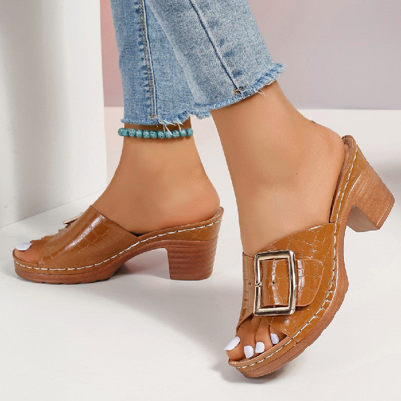 Women’s crocodile-textured buckle slides with chunky heel and peep toe.