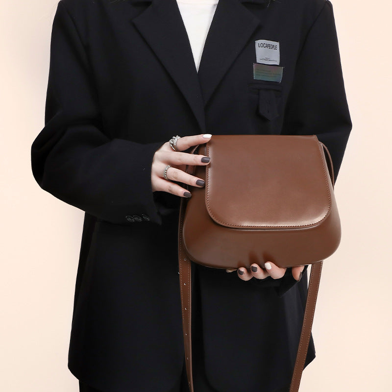 Women’s vegan leather retro saddle crossbody bag with adjustable strap.